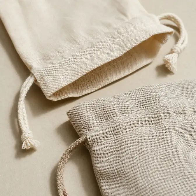 Cotton and Linen Pouch Materials Compared at the Seam Close-up comparison of cotton and linen pouch edges showing differences in weave texture, thickness, drape, folded seams, and stitching