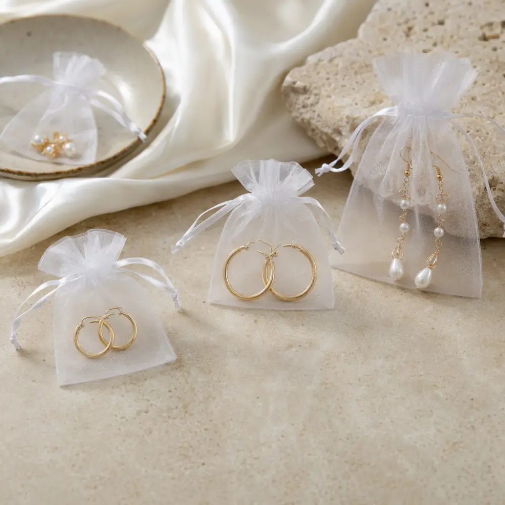 Earring Pouch Sizes for Studs, Hoops, and Drops Stud earrings, hoop earrings, and drop earrings shown in organza pouches sized to fit each style