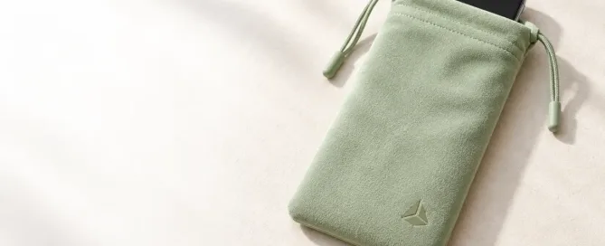 Concept visual of a pale-sage soft phone pouch with a generic smartphone partially visible.