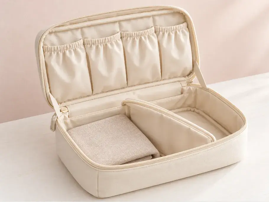 Soft Lining and Closure Details in a Lingerie Pouch Open ivory textile lingerie pouch showing soft lining, divider and zipper binding